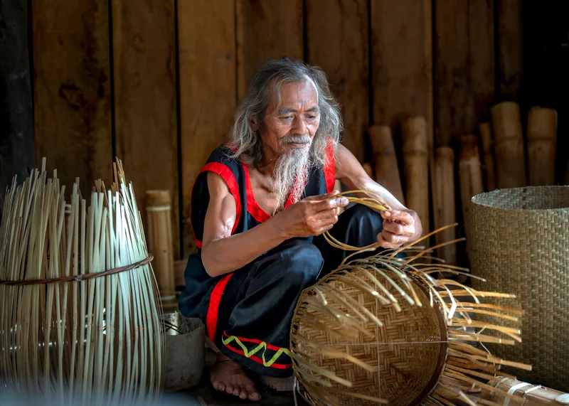 A weaver shaping a round basket from split plant fibre