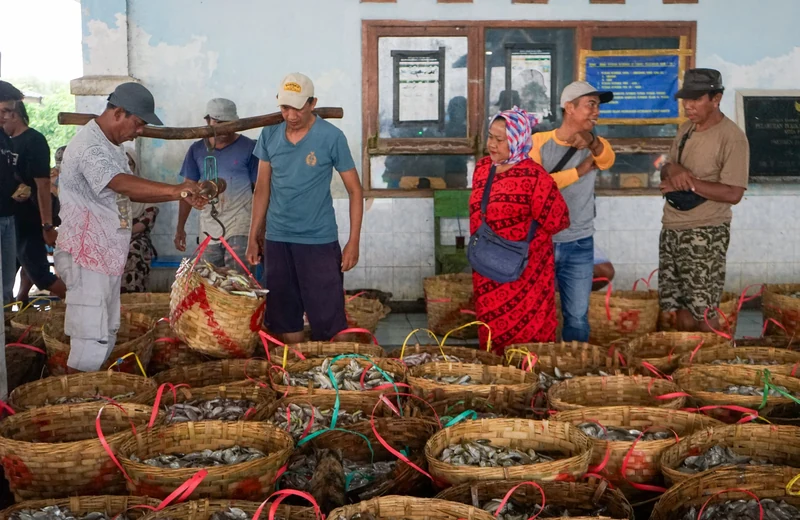 Bundles of hand-woven baskets tied and stacked at a craft market
